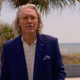 Terry Silver with long hair and blue suit.